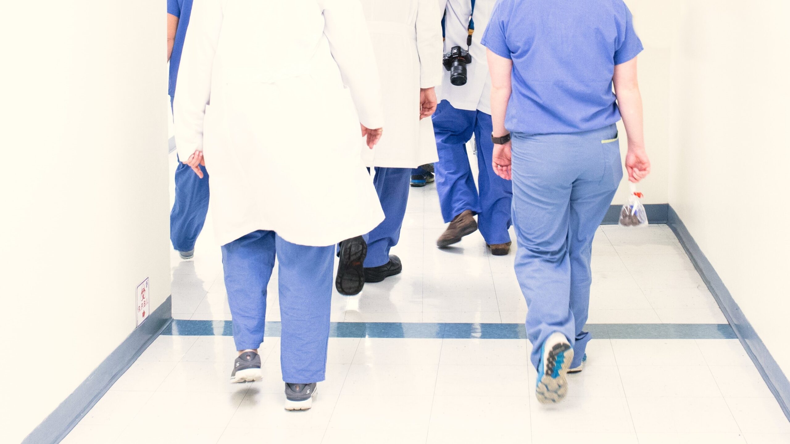 Bedürfnisse der Mitarbeitenden sollten im pflegerischen Arbeits­alltag berücksichtigt werden (KAP-Studie, Teil 4): Medizinisches Personal in Arbeitskleidung läuft durch einen Flur.